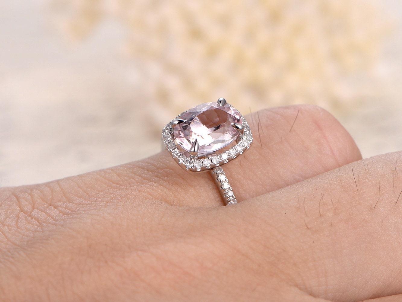 Bague de fiançailles en or rose 14 carats sertie d'une morganite ovale (7 x 9 mm) et d'un halo de diamants taille coussin.