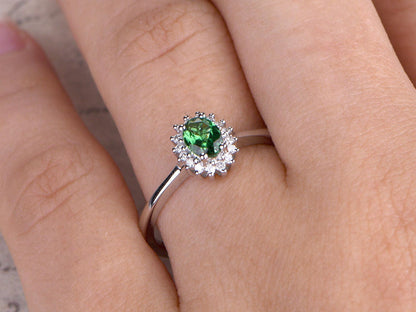 Bague en or blanc 14 carats sertie d'un diamant tsavorite ovale naturel et d'un grenat vert.