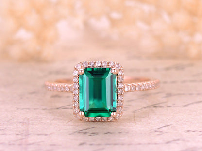 Bague de fiançailles en or rose 14 carats avec émeraude de 6 x 8 mm, pierre de naissance de mai, sertie d'un halo d'émeraude et de griffes boules.