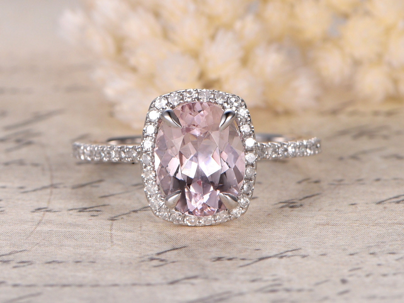 Bague de fiançailles en or rose 14 carats sertie d'une morganite ovale (7 x 9 mm) et d'un halo de diamants taille coussin.