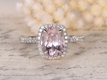 Bague de fiançailles en or rose 14 carats sertie d'une morganite ovale (7 x 9 mm) et d'un halo de diamants taille coussin.
