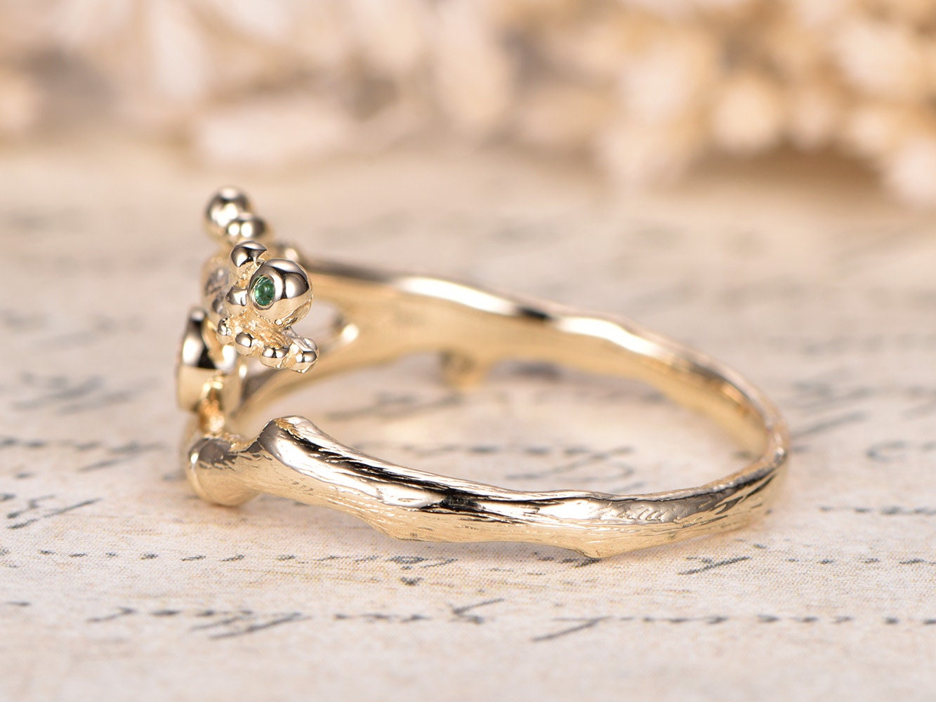 Alliance en or jaune 14 carats, finition brossée, sertie d'un diamant champagne naturel de 3 mm et d'une émeraude sertie clos. Bague de fiançailles classique à motif floral.