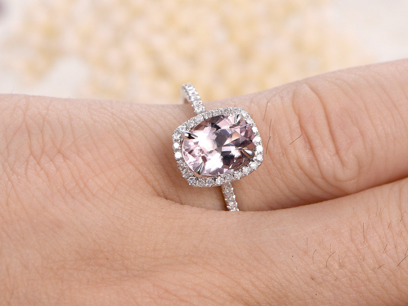Bague de fiançailles en or rose 14 carats sertie d'une morganite ovale (7 x 9 mm) et d'un halo de diamants taille coussin.