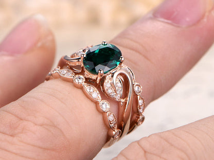 Ensemble de bague de fiançailles en or rose 14 carats comprenant une émeraude ovale et deux alliances perlées.