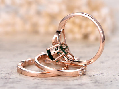 Ensemble de bague de fiançailles en or rose 14 carats comprenant une émeraude ovale et deux alliances perlées.