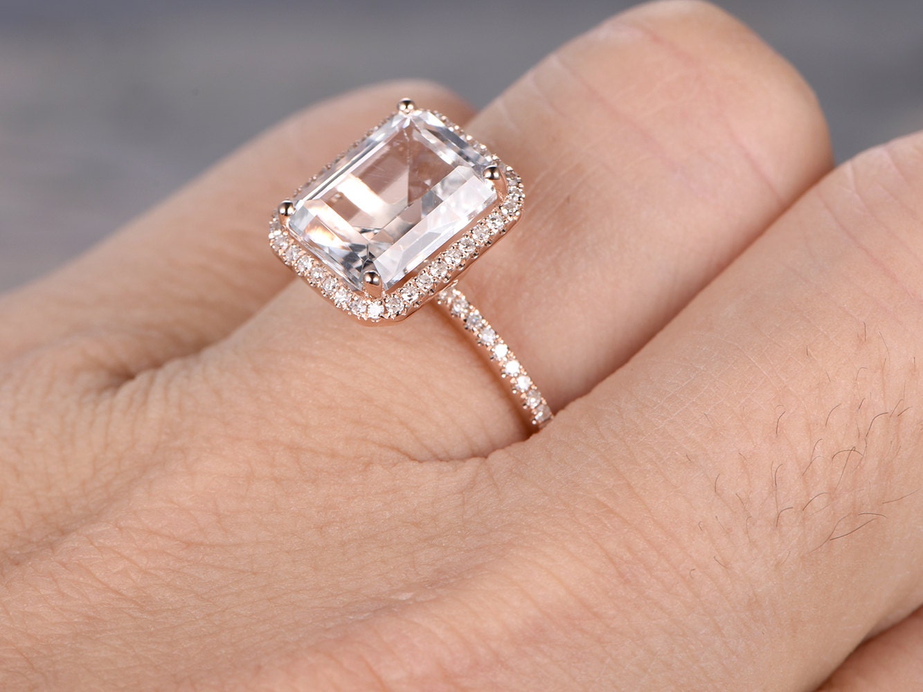 Bague de fiançailles en topaze blanche taille émeraude 8x10 mm, or rose 14 carats, sertie de diamants et ornée d'un halo. Disponible avec topaze bleue et émeraude.