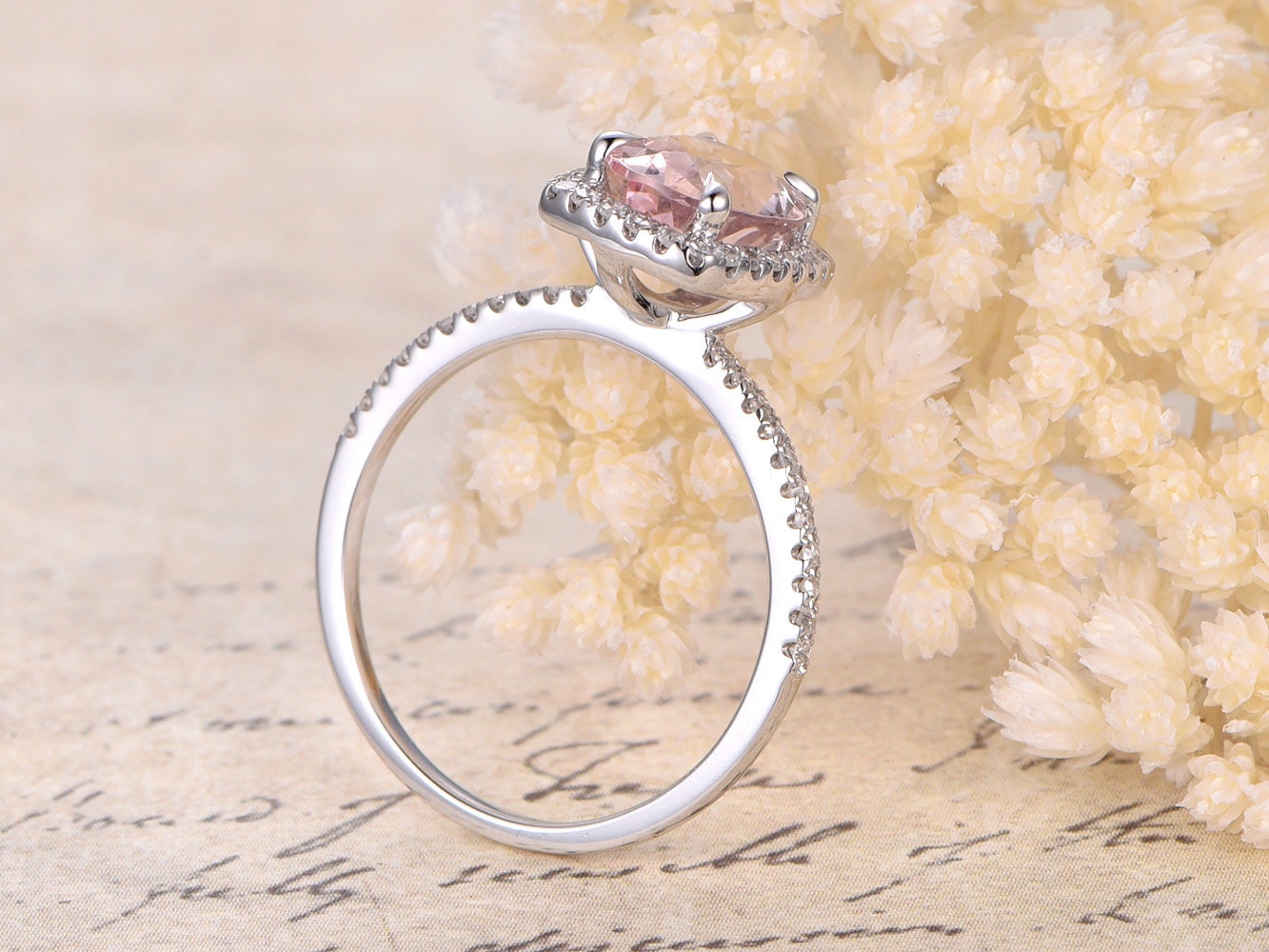 Bague de fiançailles en or rose 14 carats sertie d'une morganite ovale (7 x 9 mm) et d'un halo de diamants taille coussin.