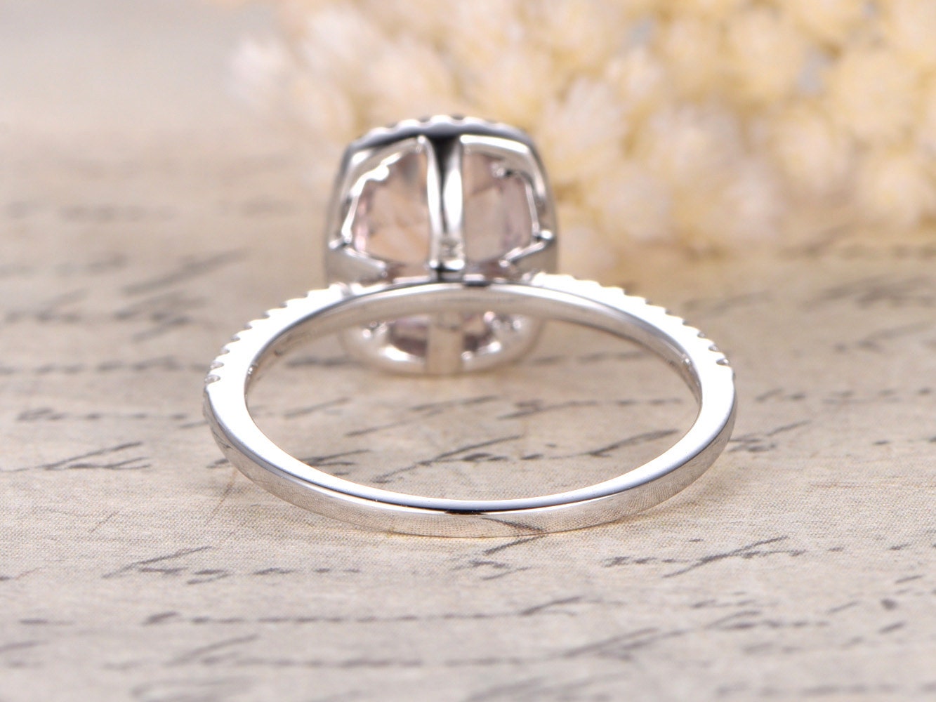 Bague de fiançailles en or rose 14 carats sertie d'une morganite ovale (7 x 9 mm) et d'un halo de diamants taille coussin.