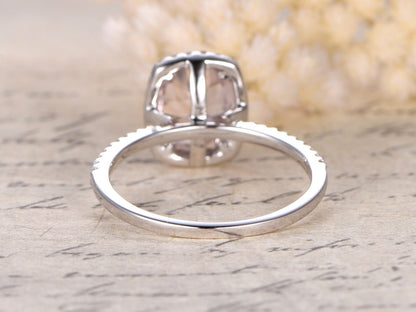 Bague de fiançailles en or rose 14 carats sertie d'une morganite ovale (7 x 9 mm) et d'un halo de diamants taille coussin.